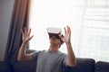 Young asian man wearing virtual reality glasses at living room for admiring virtual reality Royalty Free Stock Photo