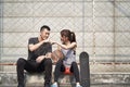 Young asian man and woman bumping fists outdoors