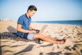 Young asian man working with laptop computer on tropical beach . Tourist Royalty Free Stock Photo