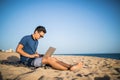 Young asian man working with laptop computer on tropical beach . Tourist Royalty Free Stock Photo