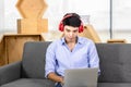 Asian man working on laptop while listening to music Royalty Free Stock Photo