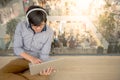 Young Asian man working with laptop while listening to music Royalty Free Stock Photo