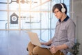 Young Asian man working with laptop while listening to music Royalty Free Stock Photo