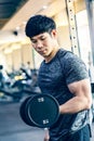 Young Asian man working out lifting heavy dumbbell at a fitness gym Royalty Free Stock Photo