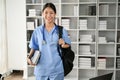 Young Asian medical student smiling and standing in the study room with stethoscope Royalty Free Stock Photo