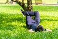 Young asian men lies on green moss relaxing with eyes closed and hands behind his head, feeling comfortable on the grass field Royalty Free Stock Photo