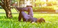 Young asian men lies on green moss relaxing with eyes closed and hands behind his head, feeling comfortable on the grass field Royalty Free Stock Photo