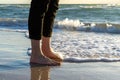 Young Asian men is standing at the sea edge and a sea wave is hitting on its feet Royalty Free Stock Photo