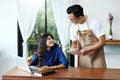 Asian man waitress taking order of woman in the cafe. Cafe restaurant service, Small business owner, food and drink industry Royalty Free Stock Photo