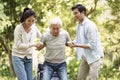 Young asian couple helping old man stand up