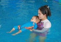 Young Asian mom teaching baby boy in swimming pool Royalty Free Stock Photo