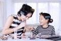 Young asian mother and daughter with hair curlers are doing nail polish at home Royalty Free Stock Photo