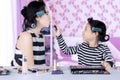 Young asian mother and daughter with hair curlers are playing with lipstick in bedroom Royalty Free Stock Photo