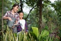 Young Asian mother and daughter happy working in the gardern together on weekend. Daughter helping mother watering