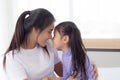 Young asian mother and daughter hug and touching nose on face with tender together. Royalty Free Stock Photo
