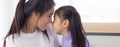 Young asian mother and daughter hug and touching nose on face with tender together. Royalty Free Stock Photo