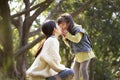 Young asian mother enjoying a good time with daughter outdoors in city park Royalty Free Stock Photo