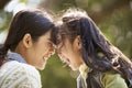 Young asian mother enjoying a good time with daughter outdoors in city park Royalty Free Stock Photo