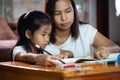 Young asian mother helping her daughter do her homework at home Royalty Free Stock Photo