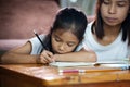 Young asian mother helping her daughter do her homework at home. Royalty Free Stock Photo