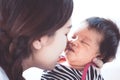 Young asian mother hugging and kissing her newborn baby girl Royalty Free Stock Photo