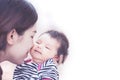 Young asian mother hugging and kissing her newborn baby girl Royalty Free Stock Photo