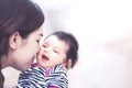 Young asian mother hugging and kissing her newborn baby girl Royalty Free Stock Photo