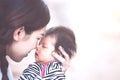 Young asian mother hugging and kissing her newborn baby girl Royalty Free Stock Photo