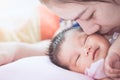 Young asian mother kissing her newborn baby girl with love Royalty Free Stock Photo