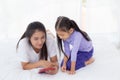 Young asian mother and little daughter looking tablet computer together for learning and education on bed in bedroom. Royalty Free Stock Photo