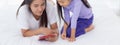 Young asian mother and little daughter looking tablet computer together for learning and education on bed in bedroom. Royalty Free Stock Photo