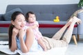 Young Asian mother lying on floor, giving cute 7 month newborn baby girl piggyback ride, enjoying active leisure time. Smiling Royalty Free Stock Photo