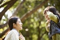 Young asian mother talking to daughter outdoors in park Royalty Free Stock Photo