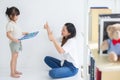 Young Asian mother taught her little daughter about reading English characters, family concept