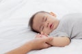 Young asian mother touch hand of little baby girl with tender on bed in the bedroom. Royalty Free Stock Photo