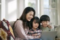 young asian mother and two children using laptop computer together at home Royalty Free Stock Photo