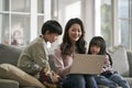 young asian mother and two children using laptop computer together Royalty Free Stock Photo