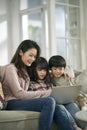 young asian mother and two children using laptop computer together Royalty Free Stock Photo