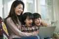 young asian mother and two children using laptop computer together Royalty Free Stock Photo