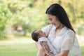 Young Asian mothers or single mom are smiling and carrying newborn babies. Family doing activities and relaxing in the park.