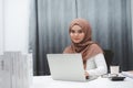 Young asian muslim business woman brown hijab sitting and working with laptop computer at home Royalty Free Stock Photo