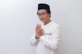 young Asian muslim man showing apologize and welcome hand gesture.  image on white background Royalty Free Stock Photo