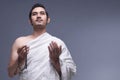 Young asian muslim man wearing ihram clothes with prayer beads