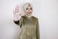 Young Asian Muslim woman wearing a brown uniform and hijab shows her palm or stop gesture Royalty Free Stock Photo