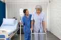 Young asian nurse at nursing home take care disabled senior woman. Caregiver doctor serve physical therapy for elderly patient to Royalty Free Stock Photo