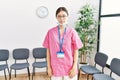 Young asian nurse woman at medical waiting room relaxed with serious expression on face Royalty Free Stock Photo