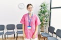 Young asian nurse woman at medical waiting room smiling looking to the side and staring away thinking Royalty Free Stock Photo