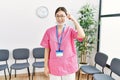 Young asian nurse woman at medical waiting room smiling pointing to head with one finger, great idea or thought, good memory Royalty Free Stock Photo