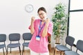 Young asian nurse woman at medical waiting room very happy and excited doing winner gesture with arms raised, smiling and Royalty Free Stock Photo