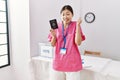 Young asian nurse woman at political campaign election holding usa passport screaming proud, celebrating victory and success very Royalty Free Stock Photo